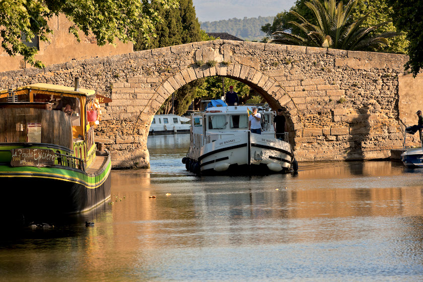 Peniche passant sous le pont du Village du Somail sur le Canal du Midi