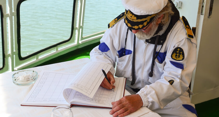 chef de bord écrivant sur son journal de bord